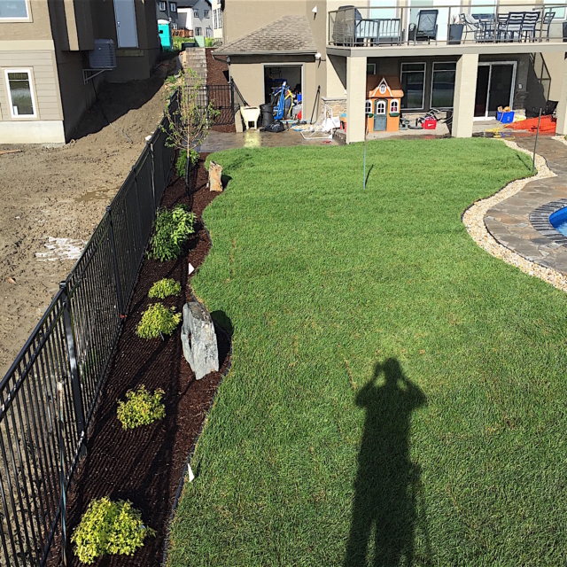 Paving Stone, River Rock, Antique brown, Boulders, Sod, brown mulch, shrubs, Black iron fence, stairs, pool